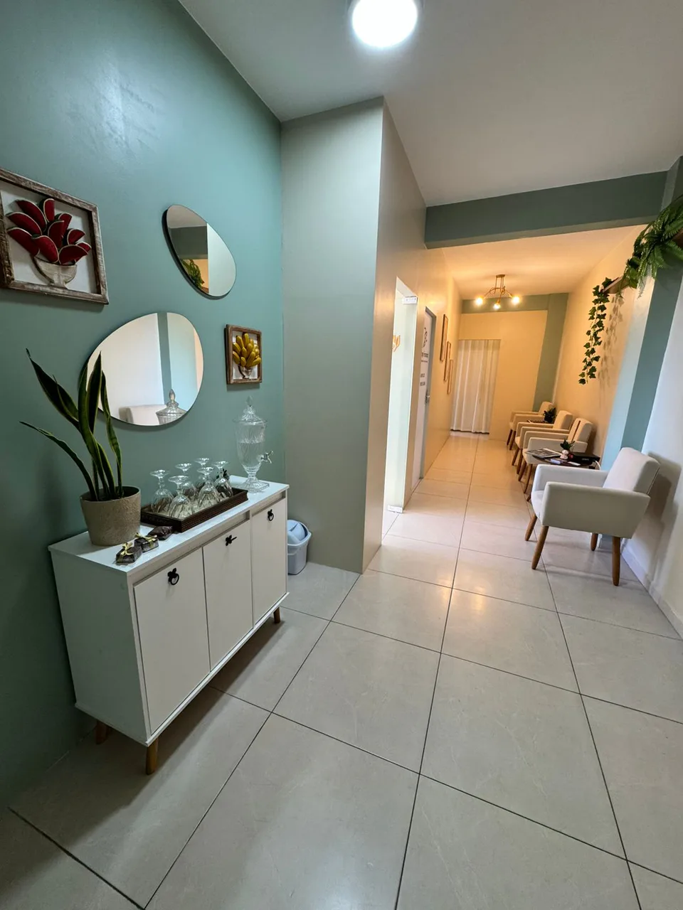 Circulação interna do consultório com assentos e elementos decorativos.