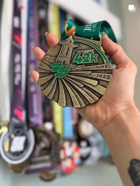 Medalha da Maratona de Jurerê 42K de 2025 nas mãos de Mariana.