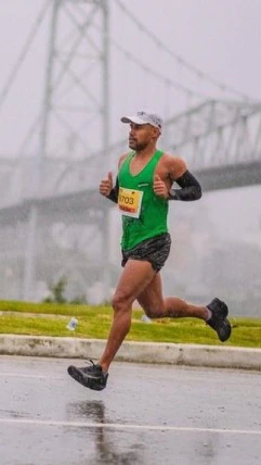 Atleta de regata verde correndo em uma prova.
